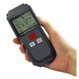 A hand holding the Digital EMF Meter, displaying a reading on its clear LCD screen.