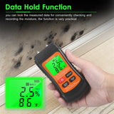 The Digital Wood Moisture Meter shown with its protective cap on, lying next to a piece of wood.